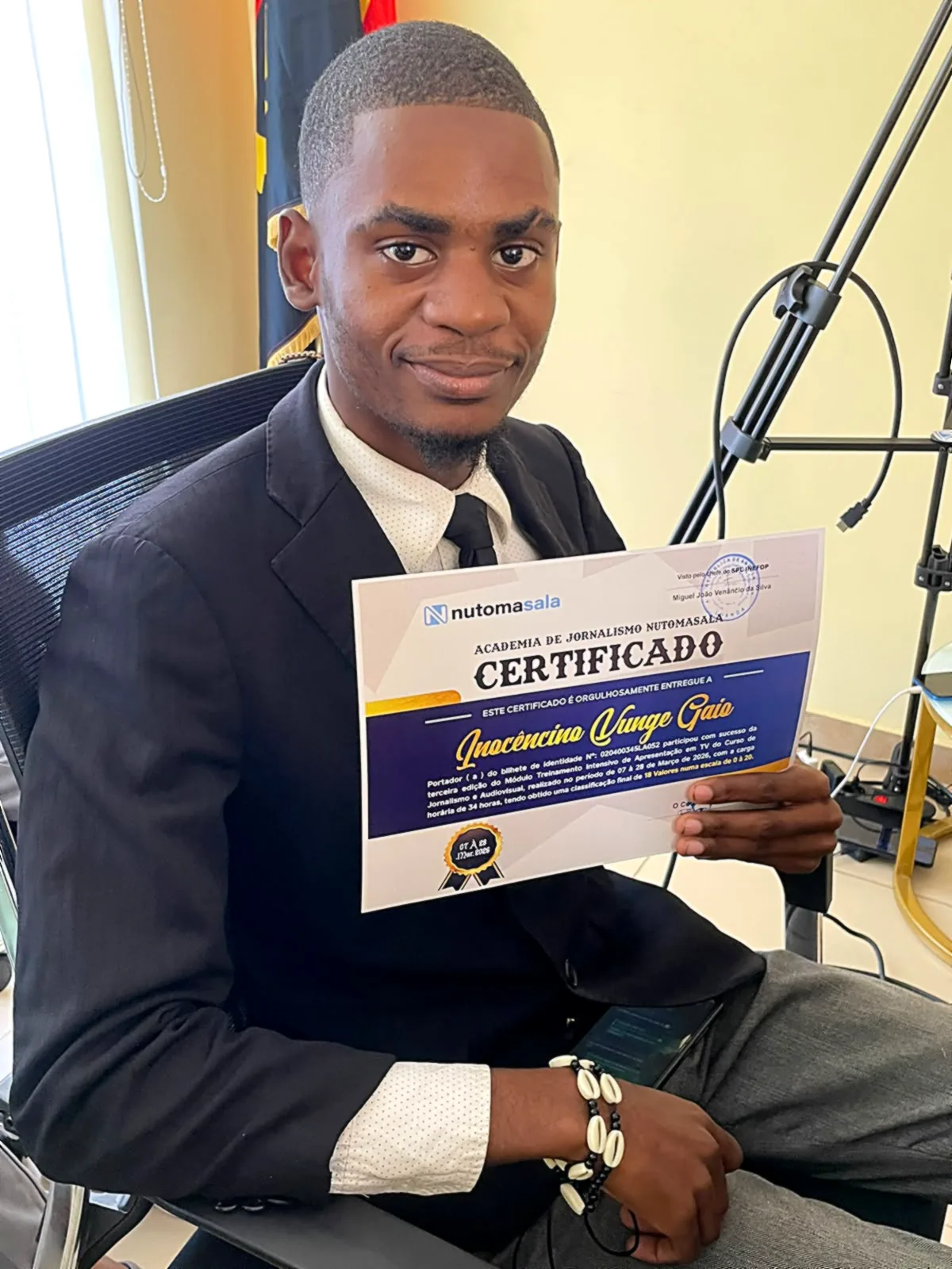 Formando de fato escuro a receber o seu certificado da Nutomasala
